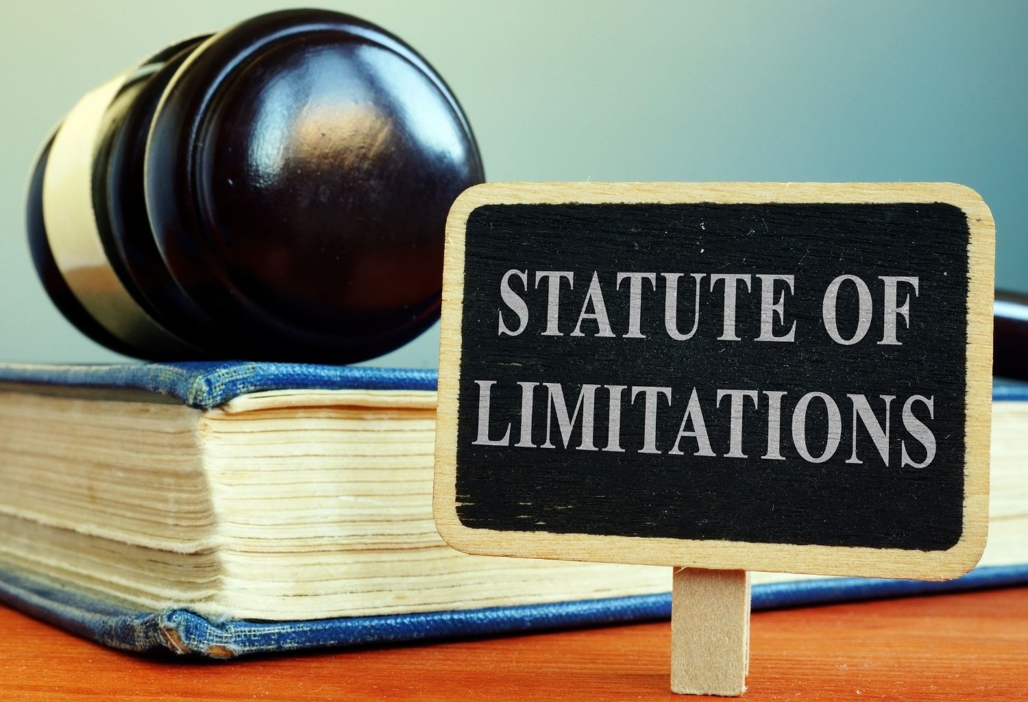 A sign reading Statute of limitations followed by a book and a gavel on top of it.