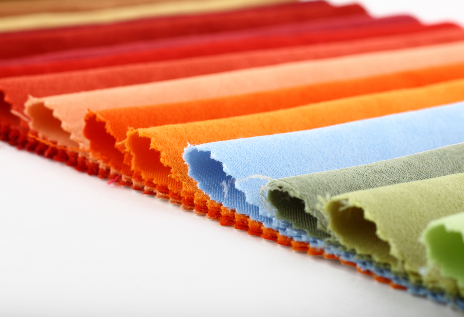 Multicolored textiles laid out on a white surface